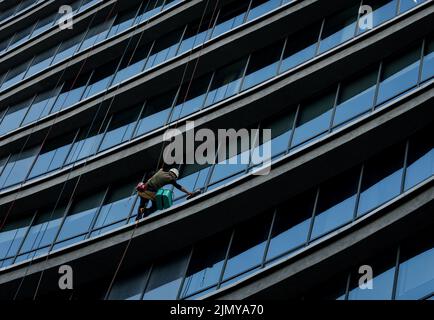 les ouvriers en hauteur lavent les fenêtres. alpinisme industriel Banque D'Images