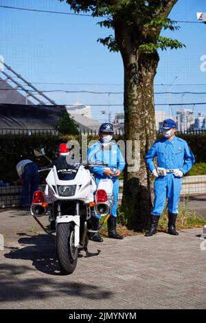 Des policiers japonais se tenant à côté de la moto de police; Japon Banque D'Images