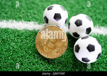 Bitcoin d'or avec ballon de football ou de football, crypto-monnaie utilisée dans les Paris sportifs en ligne. Banque D'Images