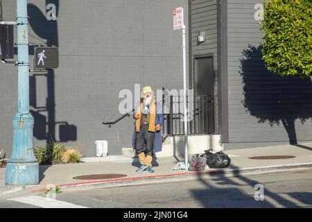 San Francisco, Etats-Unis - 20 mai 2022: Homme sans abri âgé avec ses effets personnels dans un sac en plastique au centre de San Francisco. Banque D'Images