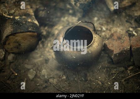 Bouilloire au feu. Faire cuire du thé sur des charbons. Détails du camping. Batterie de cuisine en acier. Banque D'Images