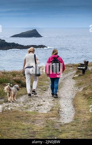 Deux femelles marchant avec un chien le long d'un sentier de la côte sur Pentire poinbt est à Newquay, en Cornouailles, en Angleterre, au Royaume-Uni. Banque D'Images