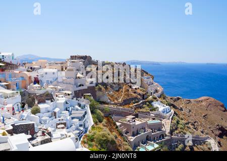 Les propriétés résidentielles et commerciales commencent à entourer l'ancien château d'Oia sur l'île de Santorini Banque D'Images