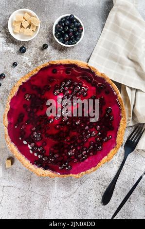 Quiche tyrolienne traditionnelle avec garniture de cassis. Tarte ouverte. Vue de dessus de la croûte de tarte maison sur la table. Tarte aux fruits maison rustique. Banque D'Images