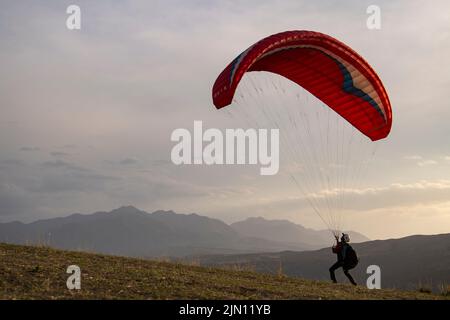 (220808) -- XINJIANG, 8 août 2022 (Xinhua) -- Chen Ruifeng pratique le parapente dans la banlieue sud d'Urumqi, dans la région autonome de Xinjiang, au 11 juin 2022, dans le nord-ouest de la Chine. Né à Xinjiang, Chen Ruifeng, 52 ans, est un amateur de parapente. Il dit qu'il a l'impression d'avoir ses propres ailes quand le parapente s'ouvre. En 2016, Chen Ruifeng a commencé à pratiquer le parapente. Plus tard, il a rejoint un club local et a reçu son certificat de vol après son entraînement. En tant qu'amateur de plein air, il s'engage également dans la course à pied, l'alpinisme et l'escalade sur glace. Dans ses opinions, le terrain unique de Xi Banque D'Images