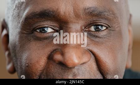 Gros plan partie visage masculin heureux personnes âgées Africain américain homme souriant avec des yeux sombres et amicaux. Beau citoyen mature et âgé ayant des rides Banque D'Images