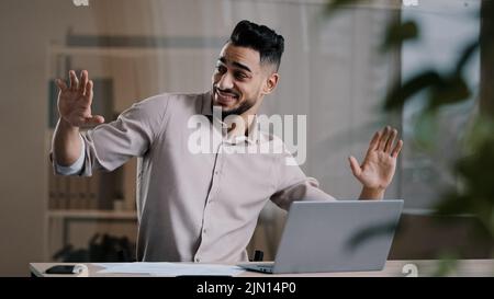 Joyeux drôle homme d'affaires arabe hispanique jeune homme millénaire homme souriant danse active au bureau à domicile a plaisir célébrer la fin du travail profiter Banque D'Images