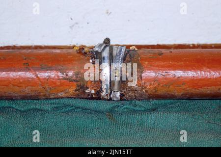 Fixer le raccord sur un tuyau d'eau qui fuit. Mise au point sélective Banque D'Images