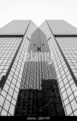 Une prise de vue en petit angle d'un bâtiment en verre moderne, en niveaux de gris et très grand, une prise de vue verticale Banque D'Images