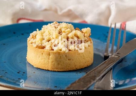 Tarte aux pommes fraîchement cuite en une seule portion sur une assiette en porcelaine bleue Banque D'Images