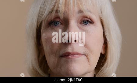 Gros plan portrait de femme en studio tête d'intérieur visage ridé calme sérieux granny mature 60s femme blonde d'âge moyen dame âgée grand-mère âgée Banque D'Images