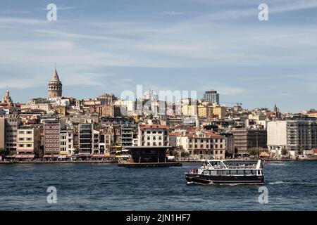 Vue sur un bateau sur la Corne d'Or, partie du Bosphore à Istanbul. La tour de Galata et le quartier de Beyoglu sont dans la vue. C'est un jour d'été ensoleillé. Banque D'Images