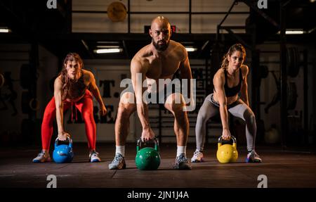 Mettre en place un groupe de personnes travaillant avec des masses ensemble lors d'une classe d'exercice dans une salle de sport Banque D'Images