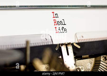 Symbole IRL dans la vie réelle. Concept mots IRL dans la vie réelle tapé sur l'ancienne machine à écrire rétro sur un beau fond blanc. Business et IRL dans Real li Banque D'Images