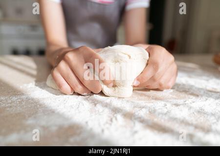 Les mains de fille avec la pâte et la farine gros plan. Banque D'Images