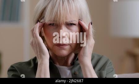 Portrait de femme intérieur bouleversé vieux mature Caucasien mal femme se sentir douleur souffrir étourdi étourdi frustré symptôme migraine senior moyenne-âge dame Banque D'Images
