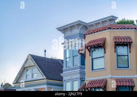 Maisons victoriennes et italianates contre le coucher du soleil au crépuscule à San Francisco, Californie. Il y a une maison italienne sur la droite avec fenêtre canopi Banque D'Images