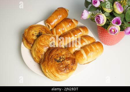 assortiment de rouleaux fraîchement cuits avec une farce dans une assiette blanche sur la table. Banque D'Images