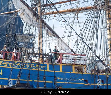 L'équipage du grand navire suédois Gotheborg, dont certains sont en uniforme maritime du 18th siècle, garde un point d'observation pendant qu'elle passe sous le pont bleu jusqu'à son quai de Thames Quay. Banque D'Images