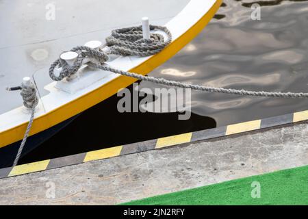 Des bollards avec des cordes d'amarrage nouées sont sur un pont de bateau Banque D'Images