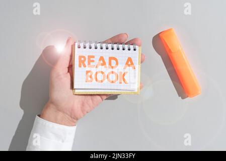 Écriture affichage de texte Lire Un livre. Concept signification appréciez la littérature traditionnelle activité apprendre de nouvelles choses femme tenant le Bloc-notes avec important Banque D'Images