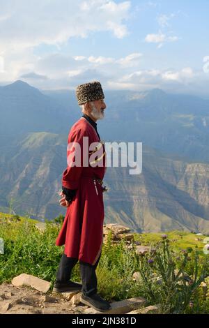 Dagestan, Russie - 21 juillet, 2022: Homme local dans la tradition nationale robe debout en profil contre les montagnes caucasiennes dans le village de Goor Banque D'Images