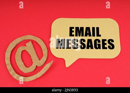 E-mail et affaires. Sur une surface rouge, un symbole et un signe avec l'inscription - E-mails Banque D'Images