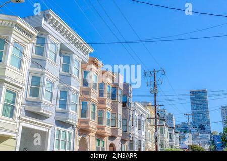 Rangée d'appartements plats aux couleurs pastel à San Francisco, CA. Il y a des poteaux électriques et des fils à l'avant des appartements et une vue de haut Banque D'Images