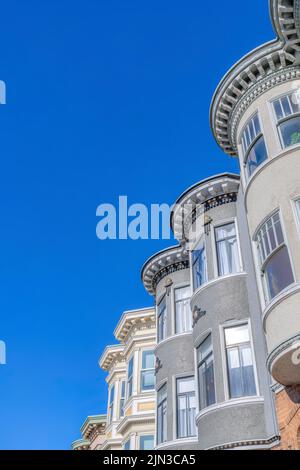 Maisons de ville victoriennes avec frises décoratives et dentiles dans une vue à angle bas à San Francisco, CA. Maisons de ville extérieures avec murs de fenêtres incurvés et décoration Banque D'Images