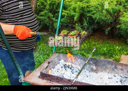 Les steaks de bœuf aux épices sur un grill sont frits sur des plats chauds. Banque D'Images