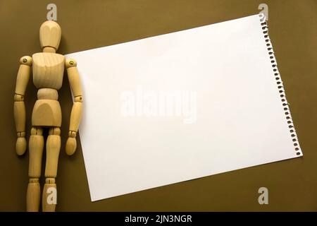 Poupée en bois et un morceau de papier vierge. Mannequin en bois avec feuilles de papier concept, espace vide. Créativité et art Banque D'Images