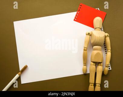 Poupée en bois et un morceau de papier vierge. Mannequin en bois avec feuilles de papier concept, espace vide. Créativité et art Banque D'Images