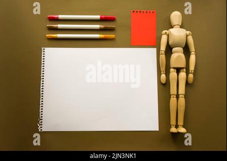 Poupée en bois et un morceau de papier vierge. Mannequin en bois avec feuilles de papier concept, espace vide. Créativité et art Banque D'Images