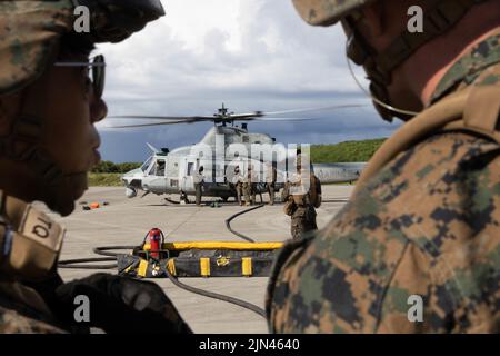 Marines des États-Unis avec le Marine Medium Tiltrotor Squadron 262 (rein.), 31st Marine Expeditionary Unit, ravitailler un AH-1W Super Cobra lors d'un exercice de point d'armement et de ravitaillement sur IE Shima, Okinawa, Japon, 04 août 2022. Un FARP est un point d'opération utilisé pour ravitailler et réarmer un avion à l'extérieur d'une base d'exploitation avant. Le MEU de 31st opère à bord des navires du Groupe amphibie Ready de Tripoli dans la zone d'opérations de la flotte de 7th pour améliorer l'interopérabilité avec les alliés et les partenaires et servir de force de réaction prête à défendre la paix et la stabilité dans la région Indo-Pacifique. (É.-U. Mars Banque D'Images