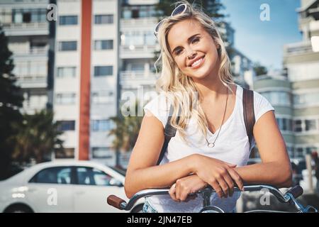 Son sourire est plus brillant que le soleil. Une belle jeune femme avec son vélo. Banque D'Images