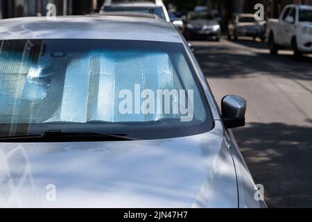 Surface réfléchissante protectrice sous le pare-brise de la voiture par temps chaud, chauffée par les rayons du soleil à l'intérieur de la voiture Banque D'Images