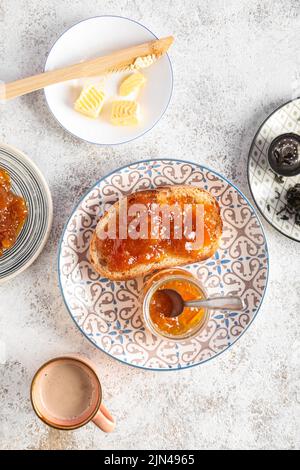 Assiette avec pain grillé savoureux, confiture d'abricot et une tasse de café sur fond de gringe Banque D'Images