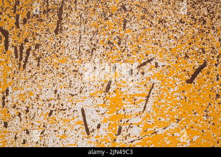 Gros plan de la peinture jaune écaillée et rayée et des motifs de rouille sur la surface métallique ferrée. Banque D'Images