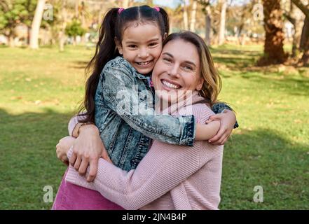 Ma fille préférée dans le monde entier. Une adorable petite fille embrassant sa mère au parc. Banque D'Images