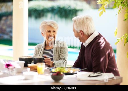 Le bonheur est écrit sur tout son visage. Un couple affectueux et expérimenté qui apprécie un repas en plein air. Banque D'Images