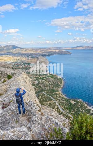 Vue de haut angle vers Sudak et Kapsel vallées de la montagne Sokol avec le touriste qui prend la photo, Crimée, Russie. Banque D'Images