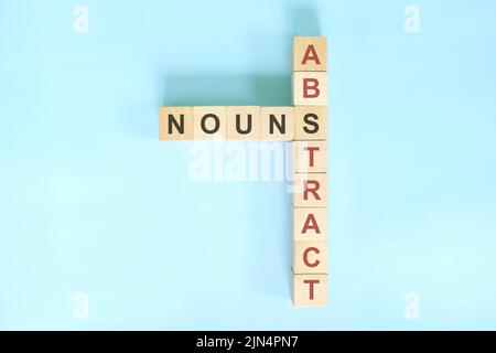Résumé nouns concept dans la grammaire anglaise noun éducation. Jeu de mots croisés en bois posé sur fond bleu. Banque D'Images