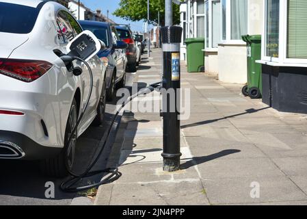 Chargement de voiture électronique blanche dans la rue à Portsmouth, Angleterre. Banque D'Images