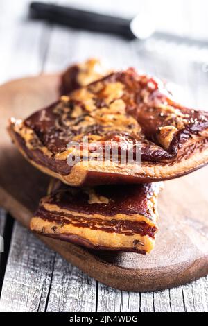 Bacon fumé entier sur une planche à découper. Banque D'Images