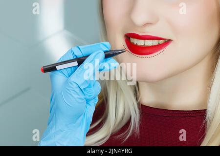 Jeune femme ayant le maquillage permanent sur les lèvres dans le salon d'esthéticienne, à proximité. Banque D'Images