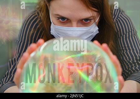 L'inscription monkeypox sur une boule de cristal pour la divination sur l'avenir. Un tueur de fortune avec une balle mystique regarde le virus du singe Banque D'Images