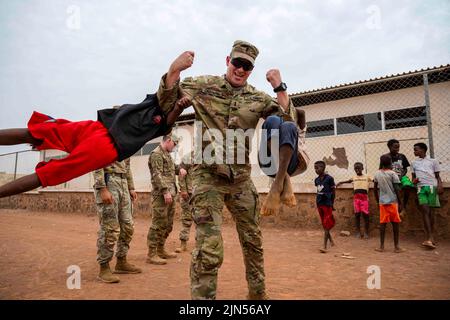 Chebelley Village, Djibouti. 15th juillet 2022. Armée américaine 1st le lieutenant Austin Chapman, 268th cadre de commandement de la compagnie de police militaire, lève deux enfants lors d'une visite au village de Chabelley, Djibouti, 15 juillet 2022. La Force opérationnelle interarmées des États-Unis-Corne de l'Afrique et 449th membres du personnel du Groupe expéditionnaire aérien, situés au Camp Lemonnier, à Djibouti, travaillent régulièrement avec les dirigeants gouvernementaux et les citoyens sur une variété de projets visant à promouvoir la stabilité en Afrique de l'est. Credit: US Air Force/ZUMA Press Wire Service/ZUMAPRESS.com/Alamy Live News Banque D'Images