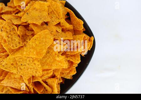 la pastille de tortilla est des chips de maïs ou des nachos, servis dans un bol, sur fond noir à base de maïs Banque D'Images