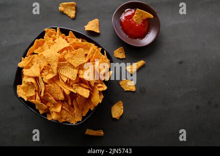 la pastille de tortilla est des chips de maïs ou des nachos, servis dans un bol, sur fond noir à base de maïs Banque D'Images