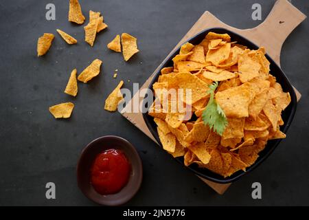 la pastille de tortilla est des chips de maïs ou des nachos, servis dans un bol, sur fond noir à base de maïs Banque D'Images